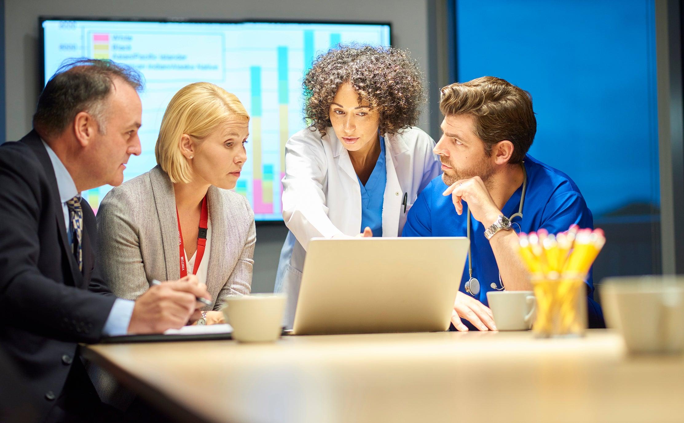 Medical professionals and corporate business executives discussing data