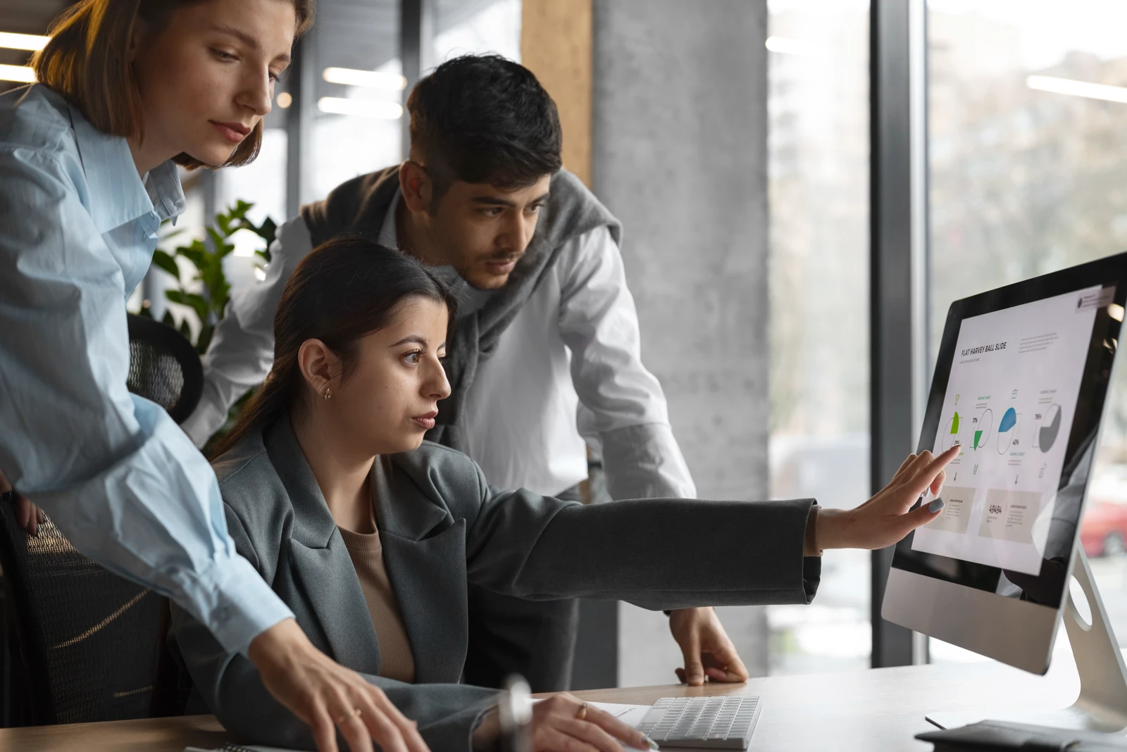 team collaborating on marketing presentation slides and business data graphics on a desktop computer