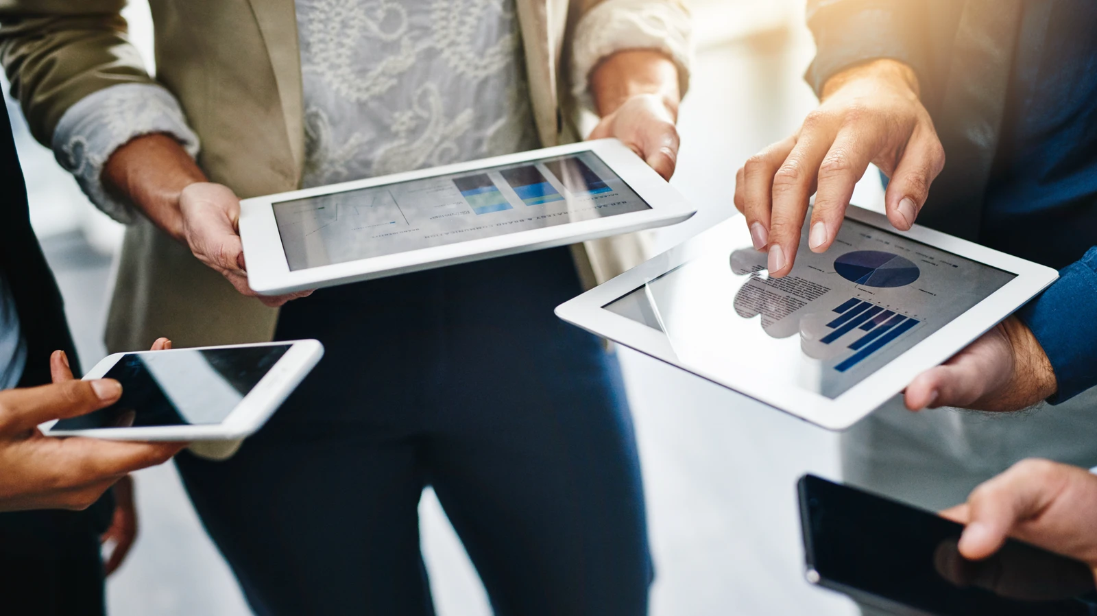 Business team reviewing real-time data analytics on mobile devices