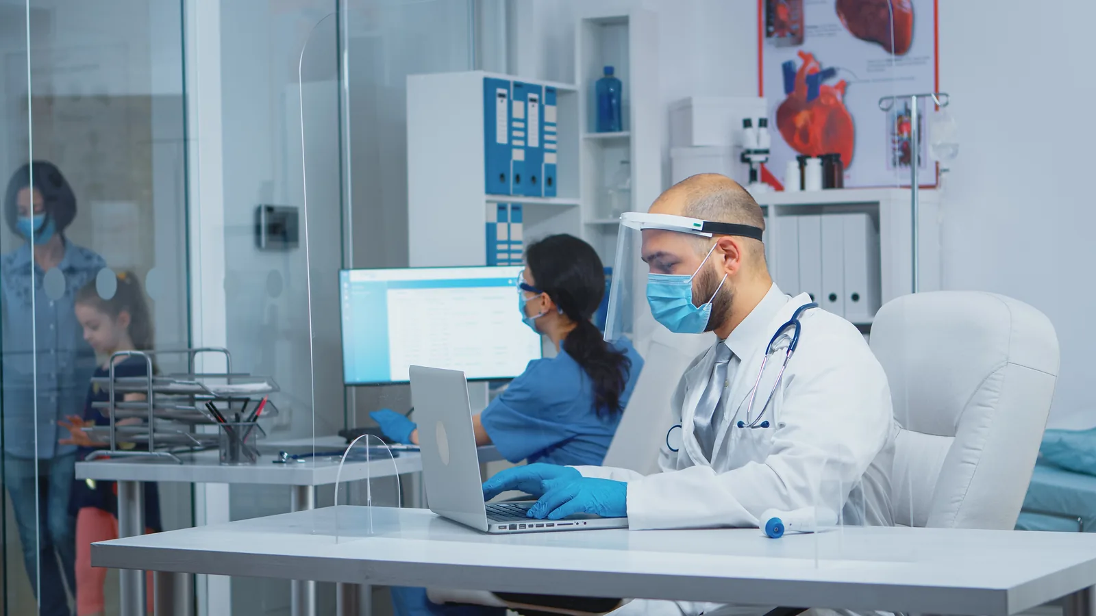 The doctor refering on a laptop